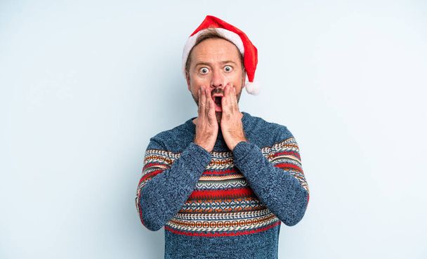 middle age handsome man feeling shocked and scared. christmas concept - Foto, imagen