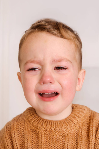 El niño triste está llorando. El niño pequeño tiene estrés, dolor y está cansado. - Foto, Imagen