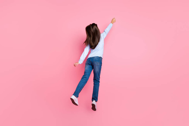 Rear back behind view full length body size of pretty girl jumping holding copy space isolated over pink pastel color background - Zdjęcie, obraz