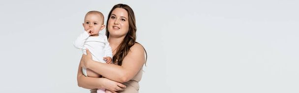 Souriant plus taille femme tenant bébé fille isolée sur gris, bannière  - Photo, image