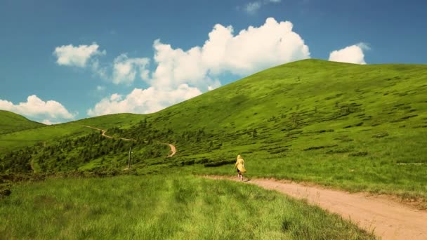 Krásná blondýnka turistka relaxaci na vrcholu Mount. Výlet, turistika. Karpatské hory na Ukrajině v letním slunném dni. Letní sezóna. Zadní pohled - Záběry, video
