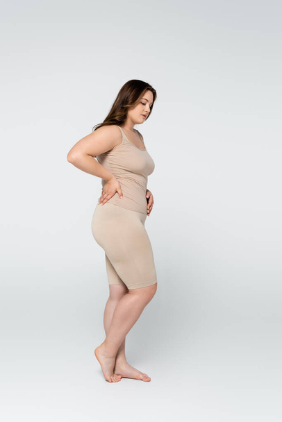 Full length of body positive woman standing on grey background - Фото, зображення