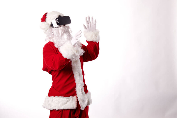 Santa Claus with virtual reality goggles on a white background - Foto, imagen