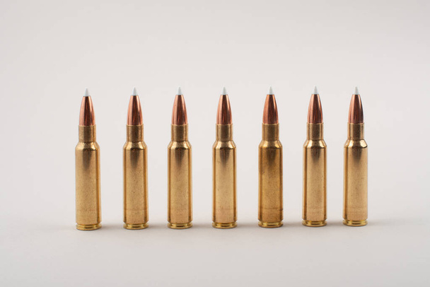Rifle bullets in a row isolated on grey background. - Valokuva, kuva
