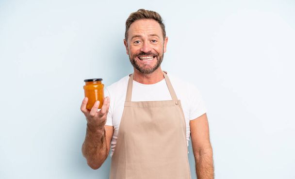 middle age handsome man looking happy and pleasantly surprised. peach jam concept - Fotografie, Obrázek