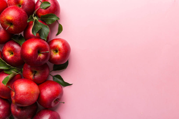 Багато червоних яблук на кольоровому фоні, вид зверху. Осінній візерунок зі свіжим яблуком над переглядом з пробілом для копіювання для дизайну або тексту
. - Фото, зображення