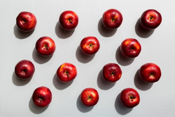 Mnoho červených jablek na barevném pozadí, horní pohled. Podzimní vzor s čerstvým jablkem nad pohledem. - Fotografie, Obrázek