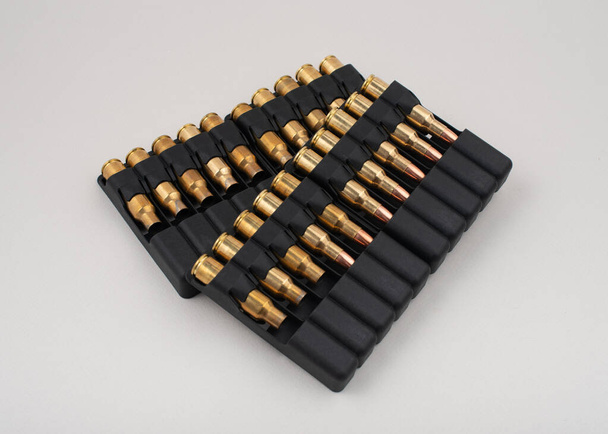 Proiettili di fucile in custodie di plastica isolate su fondo grigio. - Foto, immagini