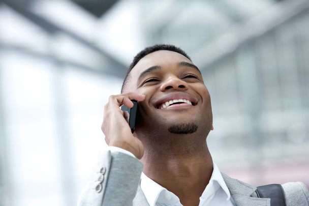 Smiling young man talking on mobile phone - Photo, Image