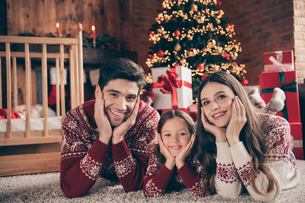 Photo of cheerful people lay floor palms cheeks relax noel miracle wear sweater in decorated flat indoors - Photo, Image