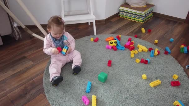 Petite fille mignonne jouant avec des jouets sur le sol à la maison. Enfance et jeu insouciants. - Séquence, vidéo