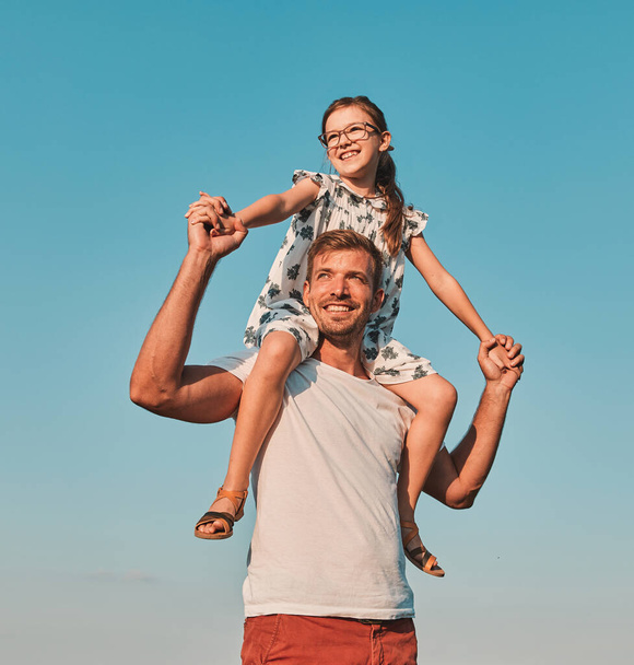 παιδί οικογένεια υπαίθρια άνθρωπος πατέρας κορίτσι ευτυχισμένη ζωή ευτυχία έχοντας διασκέδαση συγκόλληση piggyback κόρη - Φωτογραφία, εικόνα