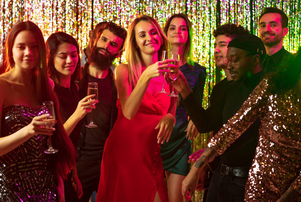 Корпоративная вечеринка. Радостная молодежь, веселящая Новый год вместе в ночном клубе - Фото, изображение