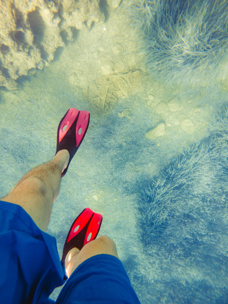 hombre piernas en aletas bajo el agua copia espacio vacaciones de verano - Foto, imagen