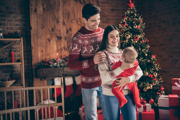 Photo of young family happy positive smile hold newborn child winter holiday decoration x-mas celebration indoors - Foto, Imagen