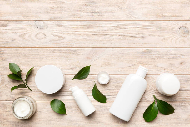 Organic cosmetic products with green leaves on wooden background. Copy space, flat lay. - Photo, Image