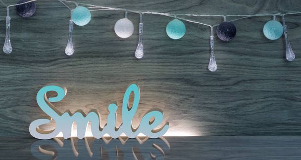Glimlach 3d expressie op een houten achtergrond met blauwe accenten - Foto, afbeelding