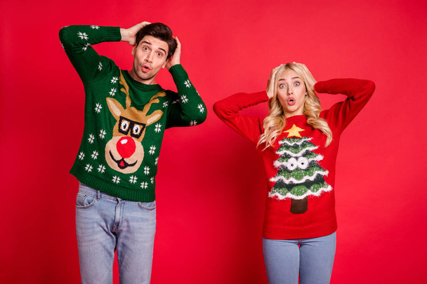 Photo portrait amazed shocked couple keeping head in sweaters isolated vibrant red color background - Φωτογραφία, εικόνα