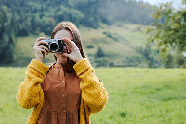 Woman taking photo with camera in mountains - Φωτογραφία, εικόνα