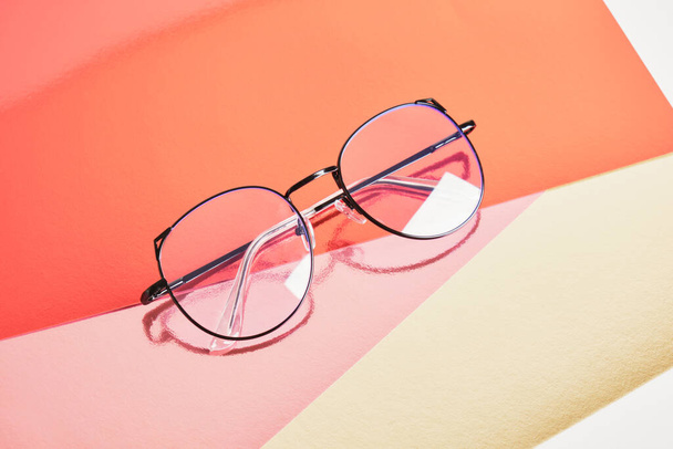 fashion trendy eyes glasses for correcting vision on a creative background, colorful pink and golden shiny cardboard background, copy space - Foto, Bild