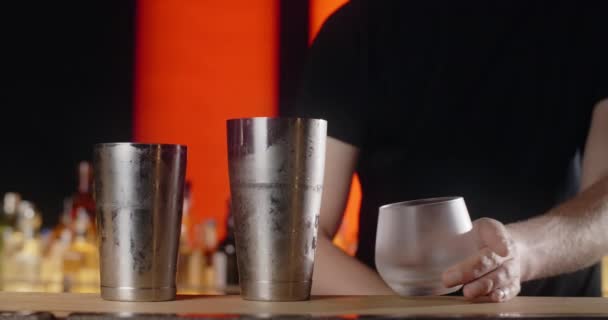 Barman zet grote ijsblokje om de bevroren cocktailglas door tang, waardoor de cocktail in de bar teller, 4k Prores HQ - Video