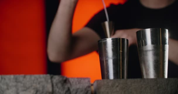 Baarimikko kaataa osan läpinäkyvästä alkoholista jiggeristä ravistimeen hidastettuna, jolloin cocktail baaritiskillä, 4k Prores HQ 120 fps - Materiaali, video