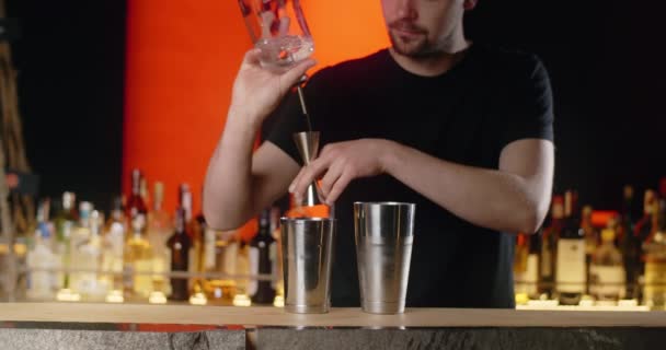 Barman ρίχνει μέρος του διαφανούς αλκοόλ από jigger στο σέικερ σε αργή κίνηση, κάνοντας το κοκτέιλ στον πάγκο μπαρ, 4k Prores HQ 120 fps - Πλάνα, βίντεο