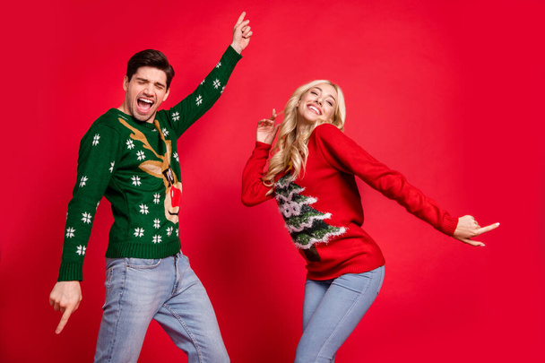 Photo portrait laughing couple wearing sweaters dancing at xmas party celebrating holidays isolated vivid red color background - Fotoğraf, Görsel