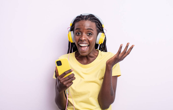 pretty black woman feeling happy and astonished at something unbelievable. listening music concept - Photo, image