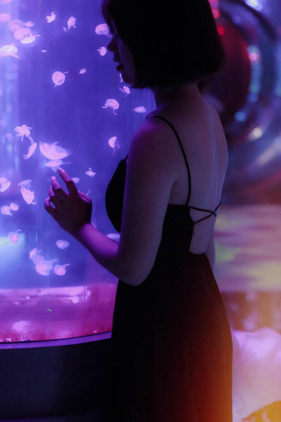 young woman in a black dress with a tattoo on the background of the night - Foto, Imagen