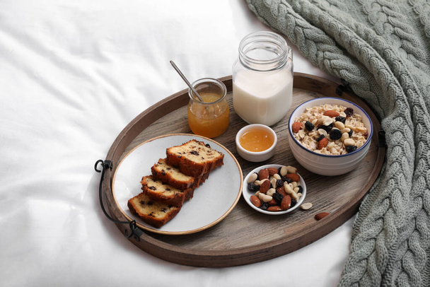 Tray with tasty breakfast on bed in morning - Foto, Imagem
