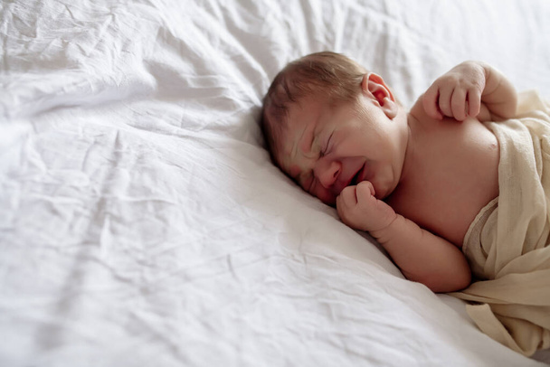 Little newborn baby sleeping on the bed in the bedroom, lulled by mom - Foto, Bild
