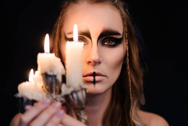 muotokuva noidasta kynttilän kanssa. Halloween mystinen ilmapiiri. Kelttiläinen mytologian jumalatar Valkyrie. Spiritismi loitsu riitti. Maskeeraa meikkipuku. Taikanoituuden okkultismi. Mystinen mieliala elämäntapa - Valokuva, kuva