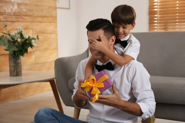 Man receiving gift for Father's Day from his son at home - Photo, image