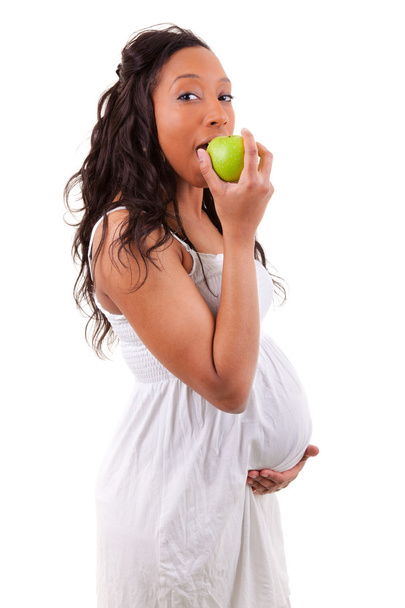 Pregnant african american woman eating an apple - Foto, Imagen