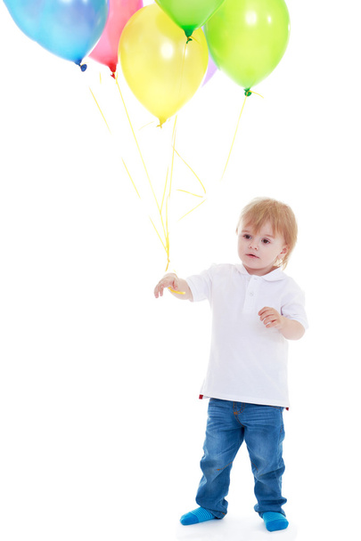 little boy holding balloons on a white background. - Foto, afbeelding