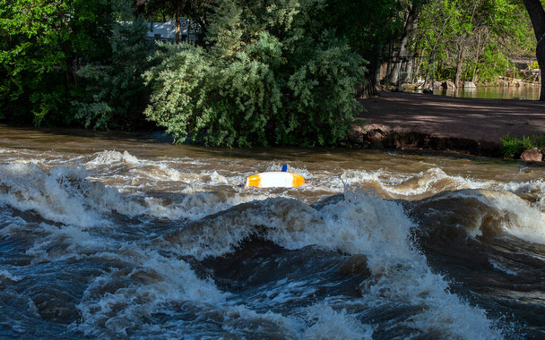 Nerozpoznatelný, ale jasně zkušený hledač vzrušení převrátí kajak na peřejích zaplavené řeky v Coloradu. - Fotografie, Obrázek