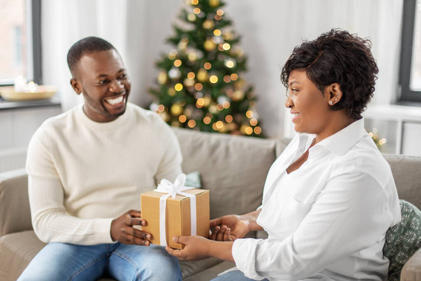 happy african couple with christmas gift at home - Photo, Image