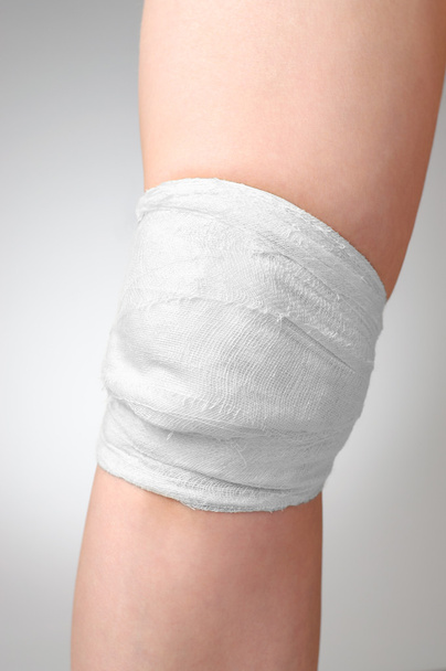 Injured knee with bandage - Фото, изображение