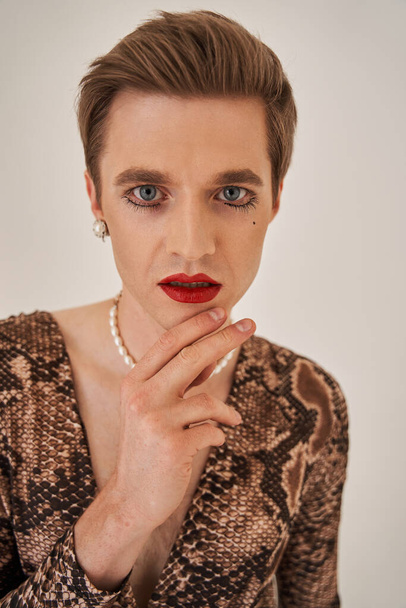 Drag queen in female clothes feeling pride and confidence in make up in studio - Fotó, kép