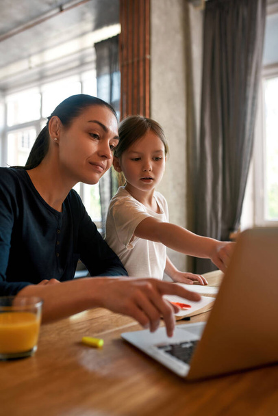 Young mom and small daughter study online on computer - Photo, Image