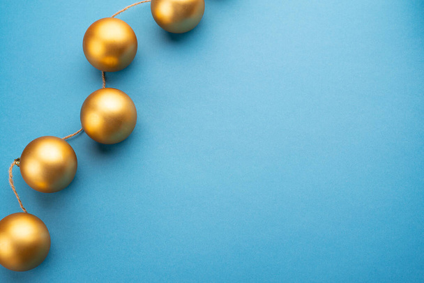 Gold Christmas balls on a light blue background. Top view.  - Foto, Imagem
