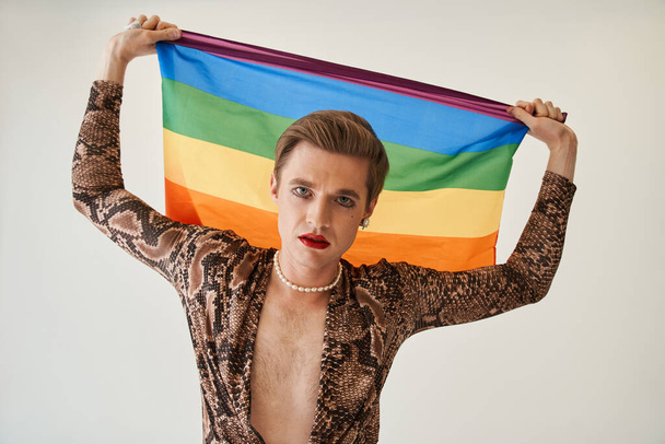 Womanlike man posing with rainbow flag while celebrating gay pride festival event - Photo, image