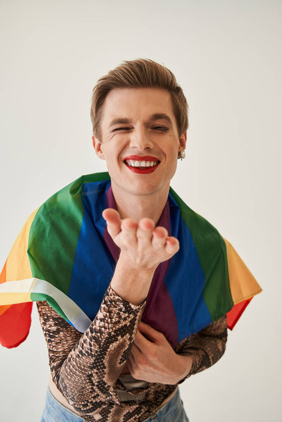 Bisexual guy in woman clothes and with make up winking to the camera - Fotó, kép