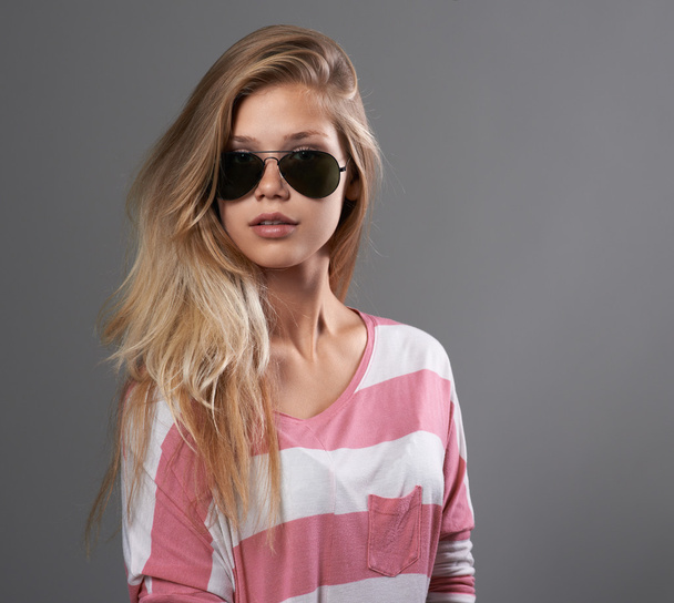 дівчина в сонцезахисних окулярах на сірому фоні
 - Фото, зображення