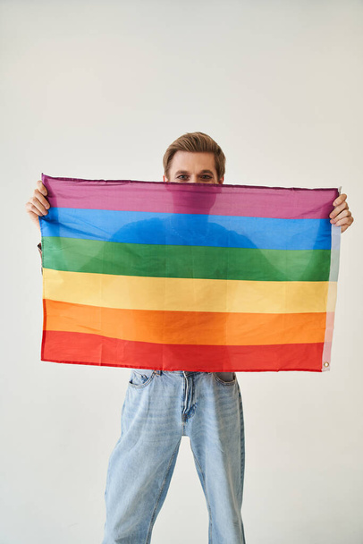 Young drag queen or womanlike male person holding rainbow lgbt flag - Foto, afbeelding