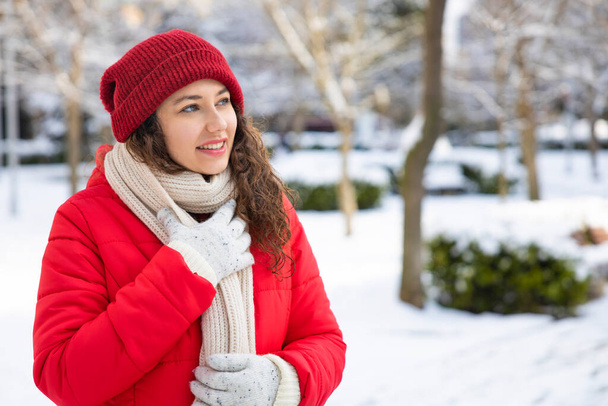 Giovane donna sorridente godendo di una giornata nevosa invernale nella cit - Foto, immagini