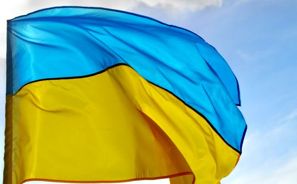 Государственный желто-синий флаг Украины над небом и облаками
 - Фото, изображение