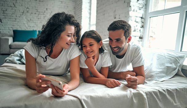 Glückliche junge Familie macht Selbstporträt mit Smartphone. - Foto, Bild