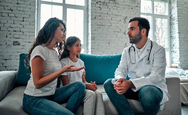 American doctor talking to young child and mother. - Foto, immagini